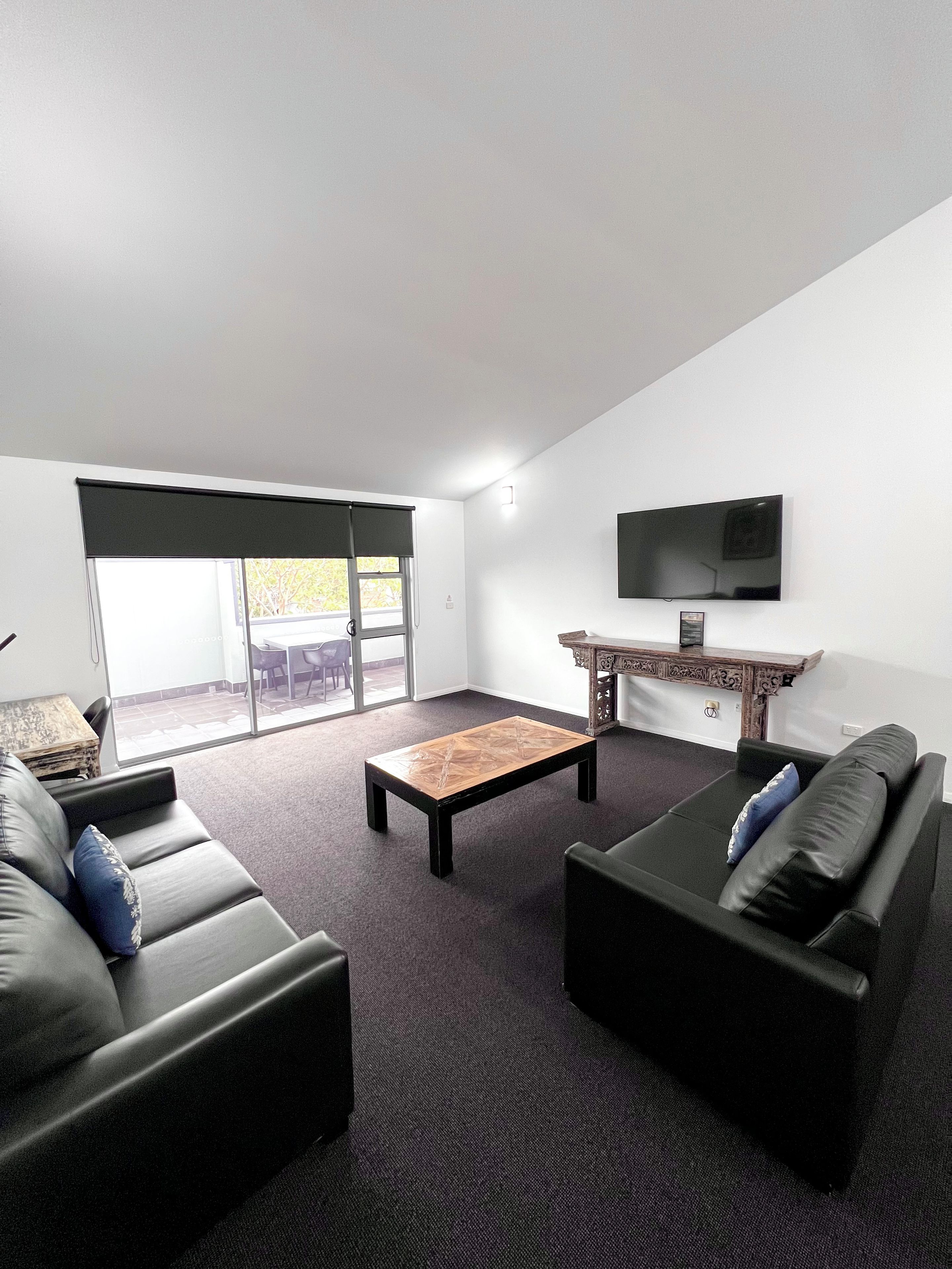 A modern living room with a sofa, a coffee table, and a TV.