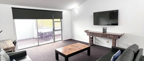 A modern living room with a sofa, a coffee table, and a TV.