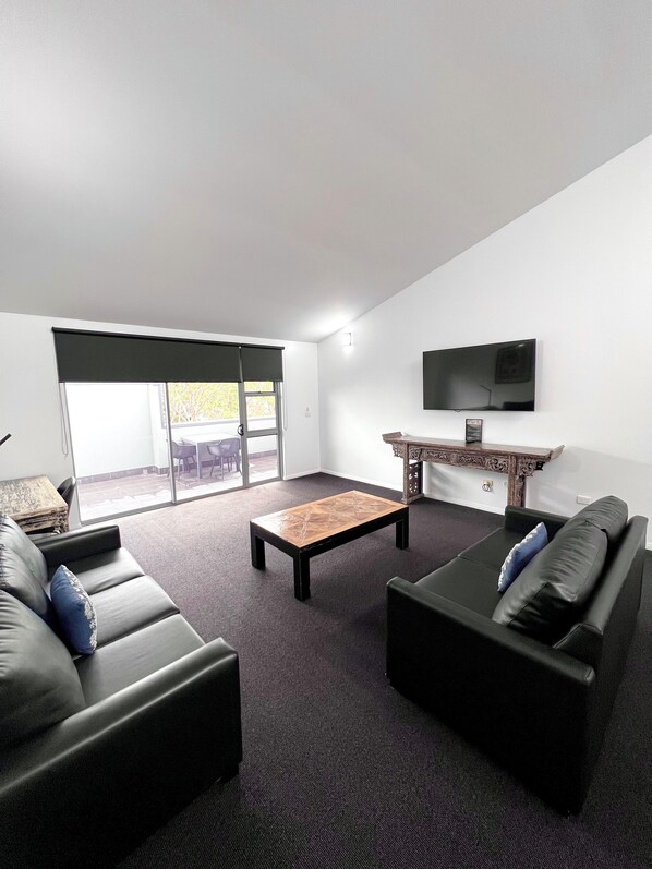 Una sala de estar moderna con un sofá, una mesa de centro y un televisor.