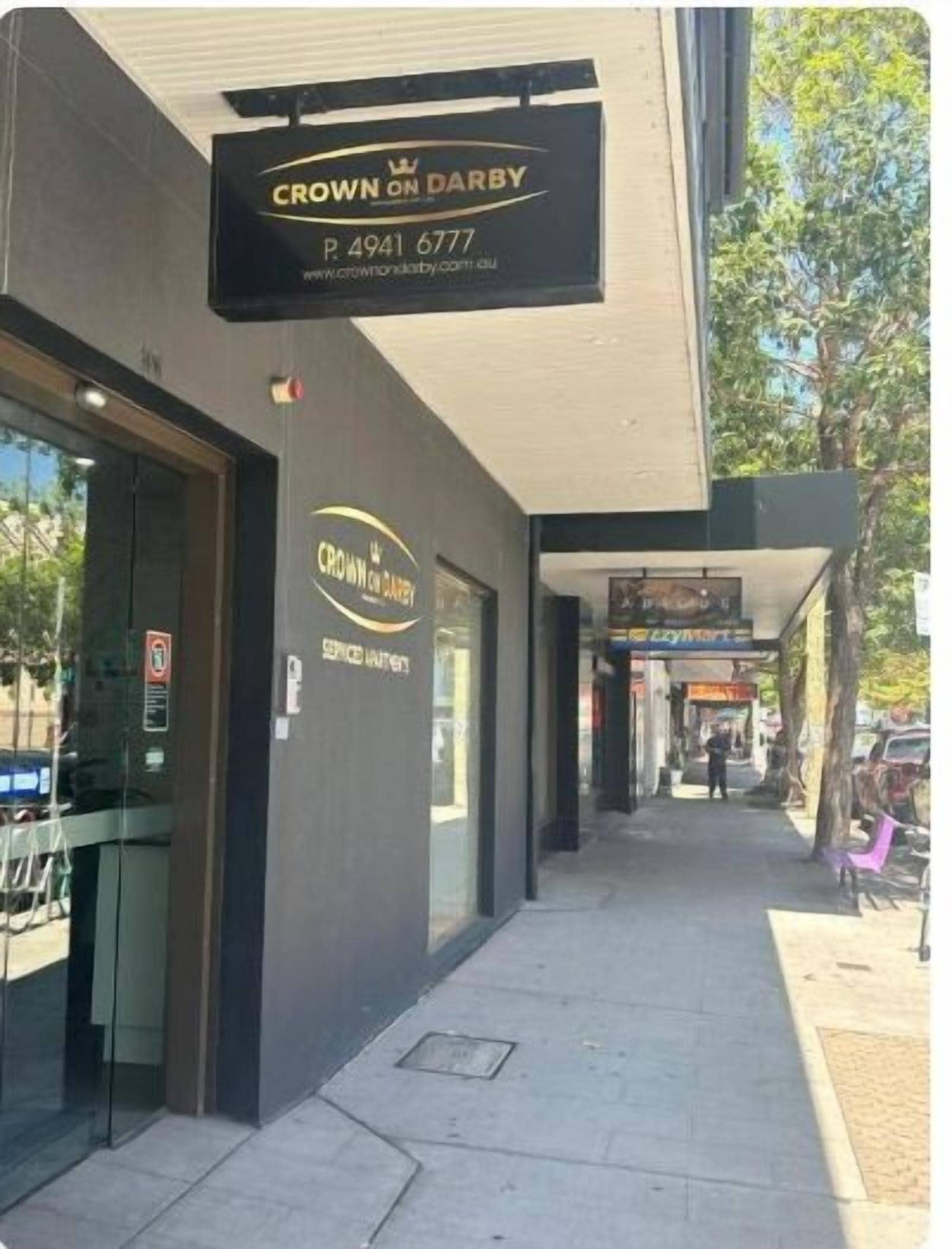 Fachada de una tienda con un letrero que dice "Crown on Darby" y un número de teléfono.