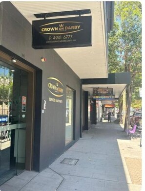 A storefront with a sign reading "Crown on Darby" and a phone number. - Crown On Darby (Newcastle)