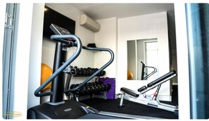 A gym with cardio equipment, dumbbells, and a mirror. - Crown On Darby (Newcastle)