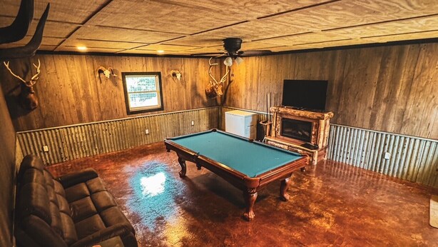A room with a pool table, a sofa, and a fireplace. - 3-bedroom cabin located in Steuben County home of 101 lakes! (Angola)