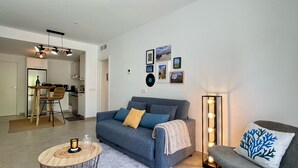 A modern living room with a sofa, a coffee table, and a floor lamp. - ETERNA Apartment in Moraira – 100 metres from the beach, 2 bedrooms, air conditioning and Wi-Fi (Moraira)