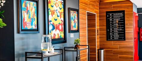 Eine moderne Lobby mit einer Holzwand, einem Empfangstresen und einem an der Wand befestigten Verzeichnis der Annehmlichkeiten.