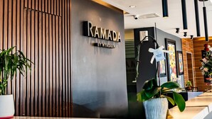 A reception area with a sign reading "RAMADA BY WYNDHAM".