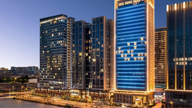Un hotel moderno de gran altura, con numerosas plantas, ventanas amplias y un diseño arquitectónico contemporáneo.