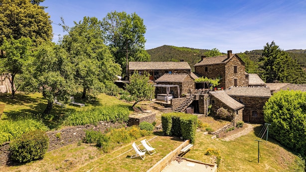 A rustic stone house with a garden, outdoor seating, and a view of the surrounding hills. - Cosy gîte with view, jacuzzi & pool - heart of the Cévennes, hiking, relaxation. (Ventalon en Cévennes)