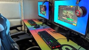 Un espace de jeu équipé de deux écrans, d’un clavier coloré et d’un casque audio.