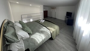 Et soveværelse med seng, fjernsyn og walk-in closet.