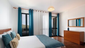 Une chambre moderne avec un grand lit, une commode en bois et une vue sur un balcon.