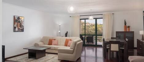 A modern living room with a sofa, coffee table, and dining area.