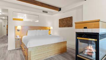 Una camera da letto con un letto di legno, un camino e una lampada a parete.