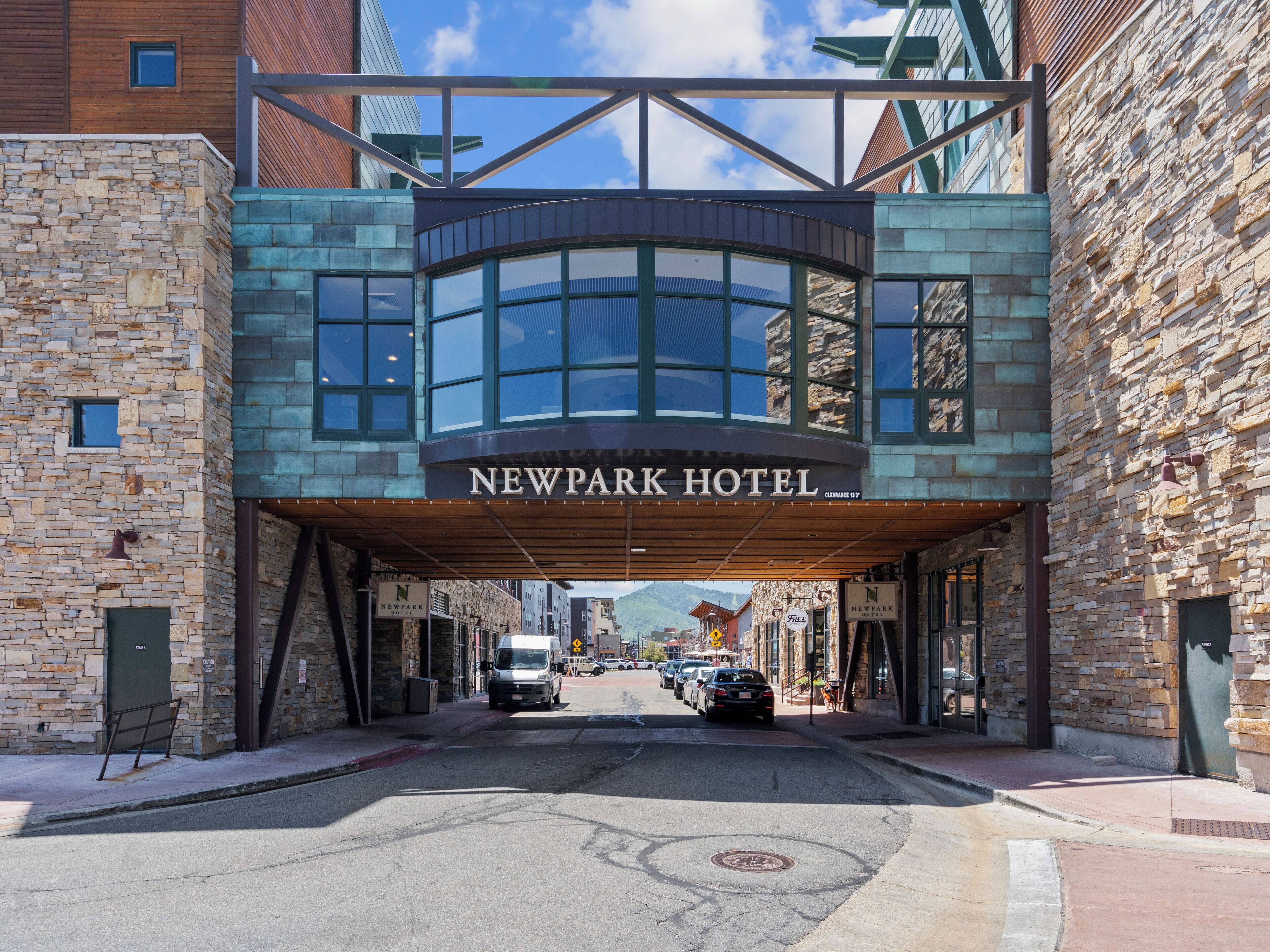 L’entrée de l’hôtel Newpark, avec sa façade en pierre et son auvent moderne en verre.
