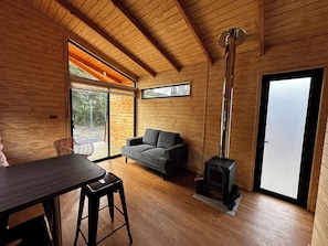 Chalet rustique familial, 2 chambres, cuisinette, vue sur la cour intérieure | Aire de séjour | Foyer