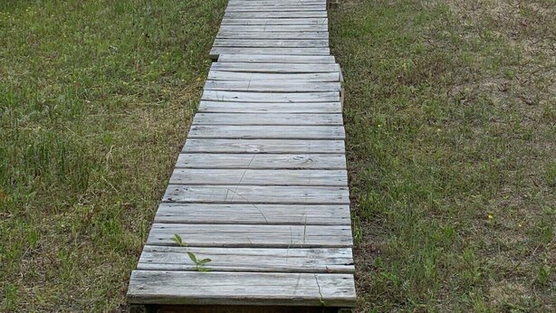 A wooden boardwalk leading to a beach.