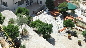A multi-story building with balconies, a courtyard with potted plants, and a view of the sea. - AZURA BAY HOTEL (Dobra Voda)
