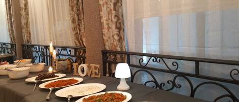 A buffet table with various dishes, a candle, and a 'LOVE' sign.