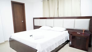 A neatly made bed with a white bedspread, a wooden headboard, and a nightstand with a drawer. - Apartment 5C Minaret (Bolívar)