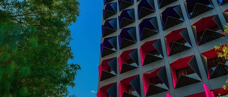 A modern building with a geometric facade and balconies.