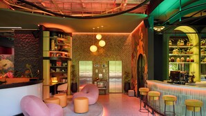 A bar area with stools, a counter, and shelves with various items. - Calle Flora Hotel by Jalo (Medellín)