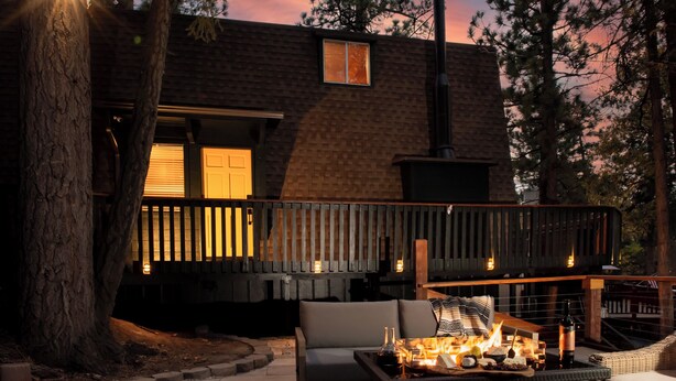 Un espacio al aire libre acogedor con una chimenea, una mesa de comedor y un sofá.