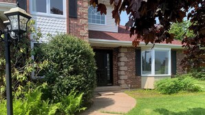 A residential house with a brick exterior, a front door, and a pathway leading to the entrance. - The Liberty House (Elegant, Stylish, Spacious) (Charlottetown)