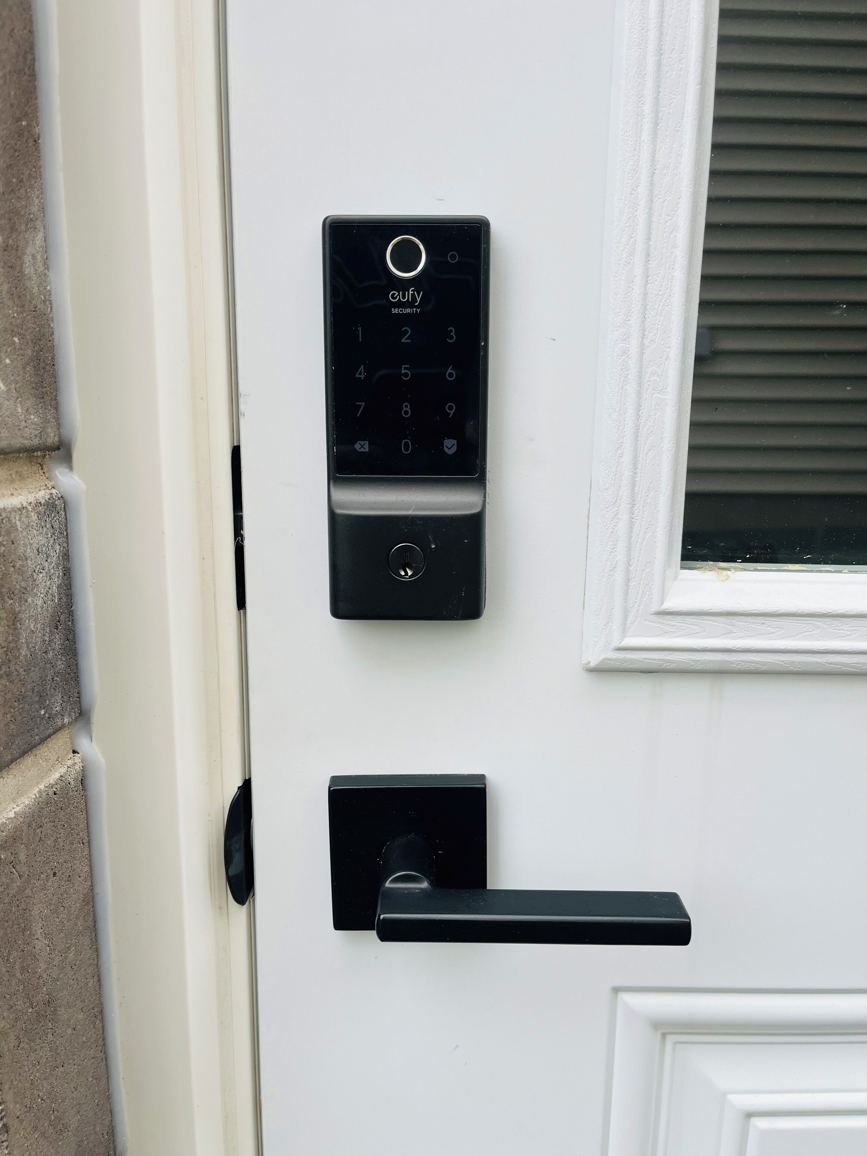 A door with a security keypad and a modern door handle.