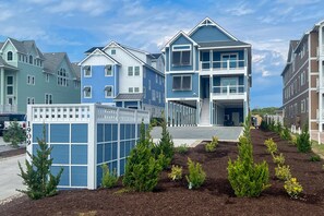 A residential area with modern two-story houses, a fenced play area, and landscaped garden beds.