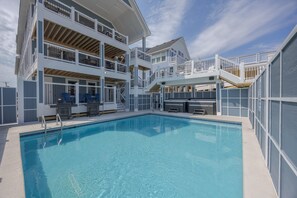 A two-story building with a swimming pool, outdoor bar, and multiple balconies.