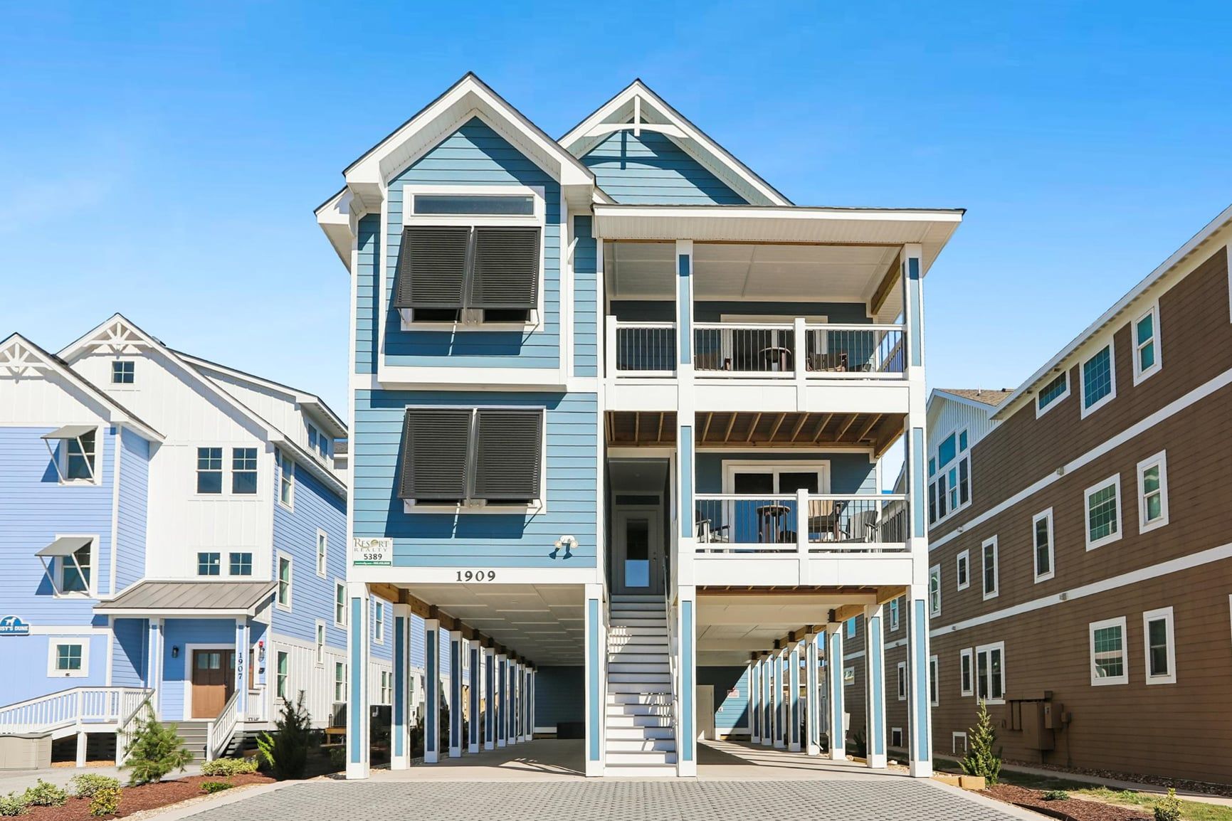 A multi-story residential building with a balcony on the second floor, a covered entrance, and a visible address number.