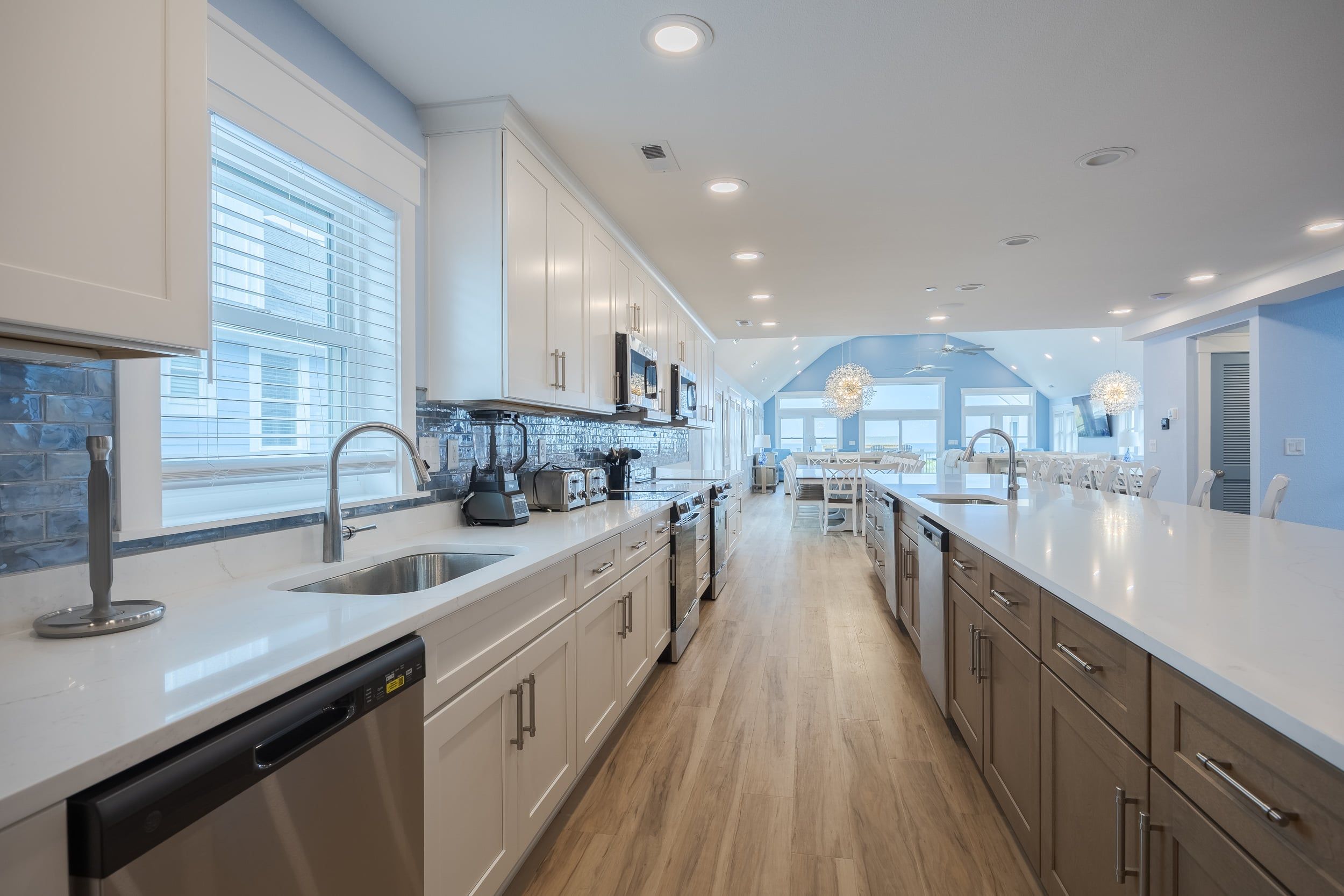 A modern kitchen with a central island, built-in appliances, and a view to the dining area.