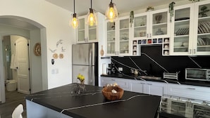 A modern kitchen with a central island, white cabinetry, and pendant lighting. - Romantic Beachfront Retreat - Everything You Want, In Las Terrenas - 2 Rooms (Las Terrenas)