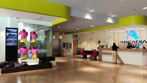 A modern interior with a reception desk, a glass display with mannequins, and a clean, polished floor.
