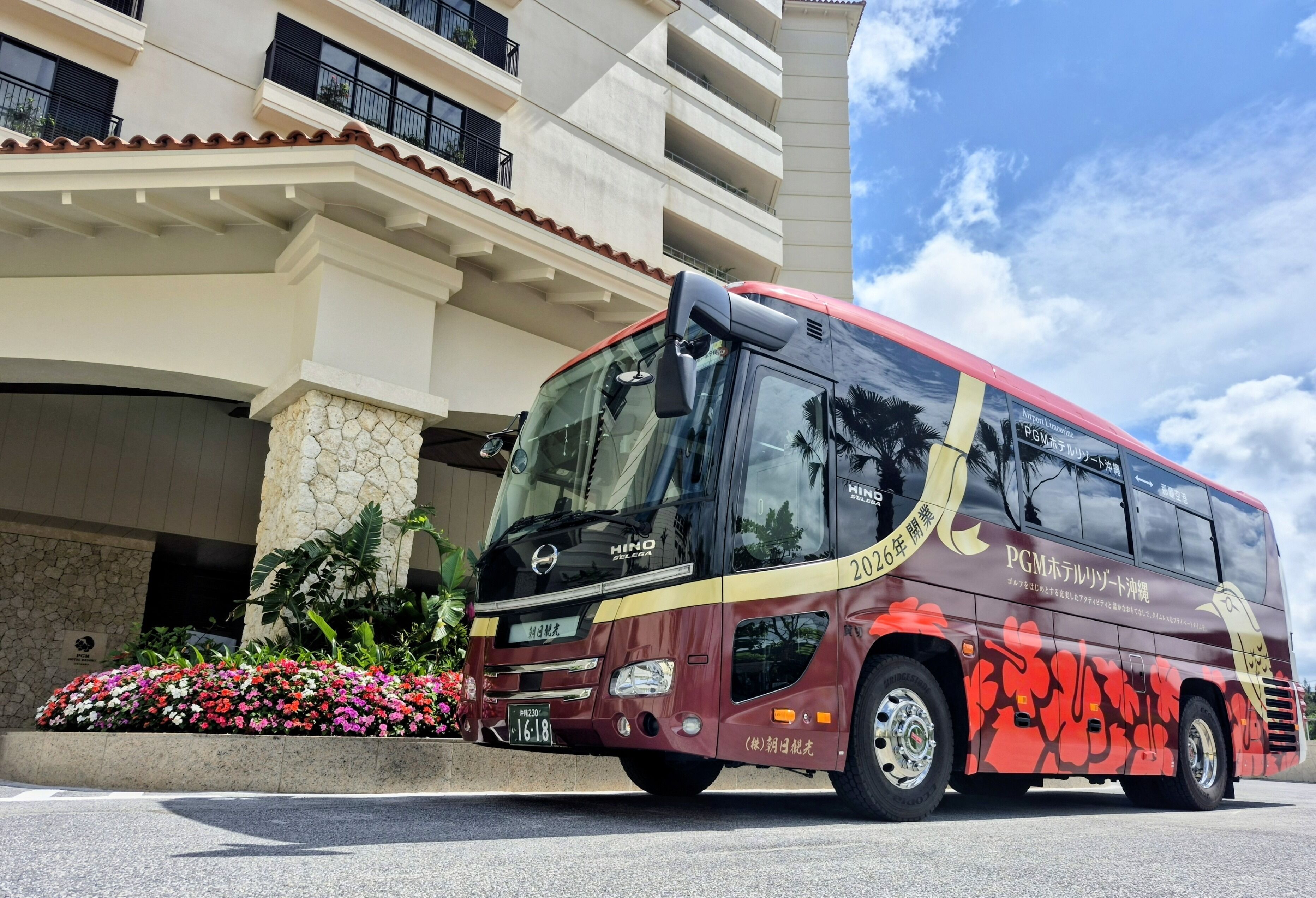 Un autobus est garé devant un immeuble dont la façade est en pierre et qui possède des balcons.