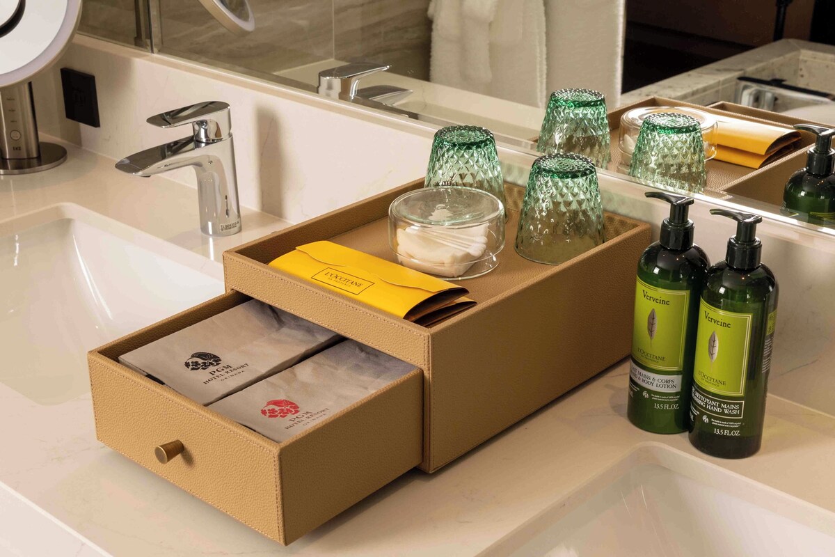 A bathroom with a mirror, sink, and toiletries.
