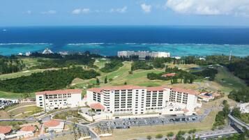 Ein Resort mit einem großen Gebäude, einem Parkplatz und Blick auf den Ozean.