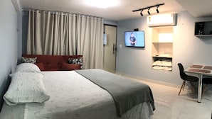 Ein Hotelzimmer mit Bett, Fernseher, Kaffeemaschine und Esstisch.