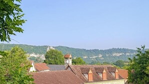Et boligområde med traditionelle bygninger, klar himmel og et bakket landskab i baggrunden.