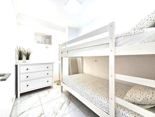 A bunk bed room with a white dresser and a small shelf with decorative items. - Adas Nirvana, Heart of Los Cristianos (Los Cristianos)