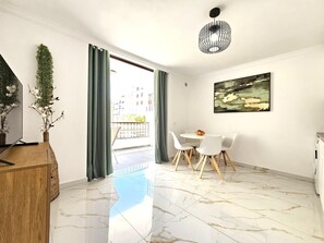 A modern living room with a dining area, a large window with curtains, a hanging light fixture, and a painting on the wall. - Adas Nirvana, Heart of Los Cristianos (Los Cristianos)