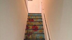 A staircase with floral-patterned steps and a white handrail.