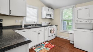 A kitchen with white cabinets, a microwave, stove, and dishwasher.
