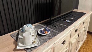 A dining area with a TV, a tray with cups and plates, and a remote control. - ☀️🌳🏡🦔Dimora del Riccio (Bergamo)