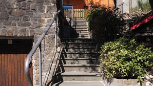 A stone staircase leading to a building with a wooden door and a metal railing. - ☀️🌳🏡🦔Dimora del Riccio (Bergamo)