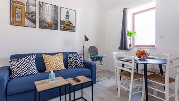 Familie appartement, 1 tweepersoonsbed met slaapbank, kitchenette, uitzicht op de stad | Woonruimte | Televisie