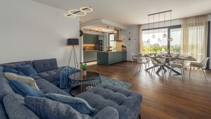 A modern living room with a sectional sofa, a dining area with a table and chairs, and a kitchen in the background. - Villa Villa Mattia (Istria - Novigrad) (Novigrad)