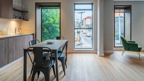 Eine moderne Küche mit Essbereich, großen Fenstern und Blick auf die Straße.