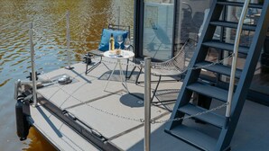 A modern boat with a glass-enclosed deck, a metal staircase, and a seating area with cushions. - Floating Home-Hausboot Saarschleife by Interhome (Mettlach)