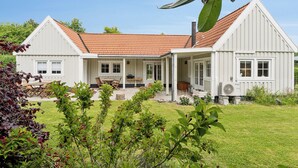 A two-story house with a red-tiled roof, a covered patio, and a lawn. - Renovated summer house in Vejby/ Tisvilde (Vejby)